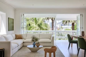 Cream bespoke corner sofa and green dining chairs in a bright room with balcony views
