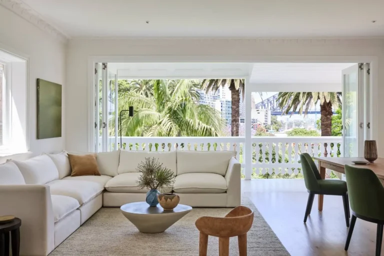 Cream bespoke corner sofa and green dining chairs in a bright room with balcony views